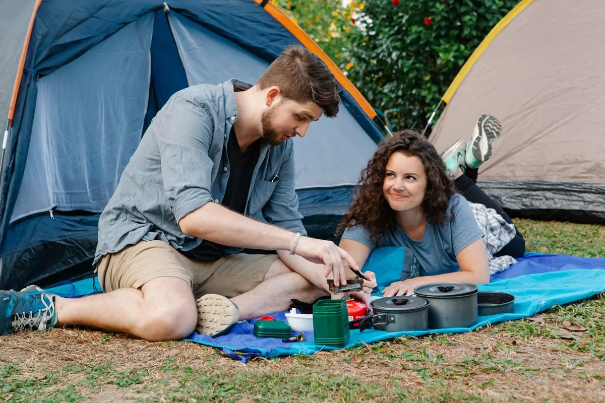 Campers preparing food beside a tent